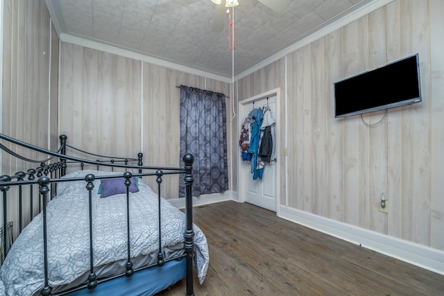 bedroom featuring ceiling fan, baseboards, wood finished floors, and crown molding