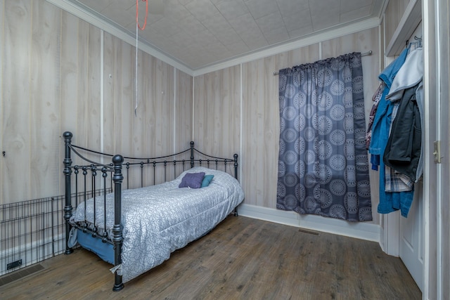 bedroom with visible vents, hardwood / wood-style flooring, and ornamental molding