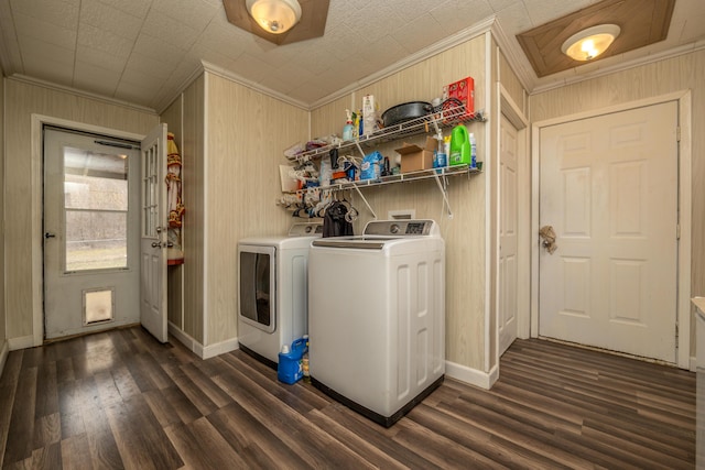 clothes washing area with dark wood-style flooring, washing machine and dryer, laundry area, and ornamental molding