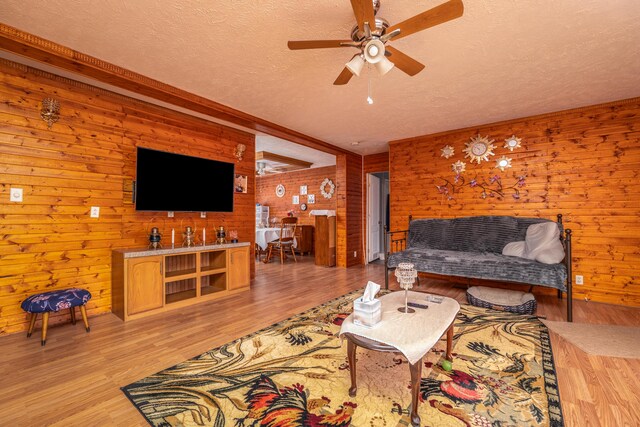 dining area featuring a ceiling fan, wood finished floors, visible vents, a textured ceiling, and a raised ceiling