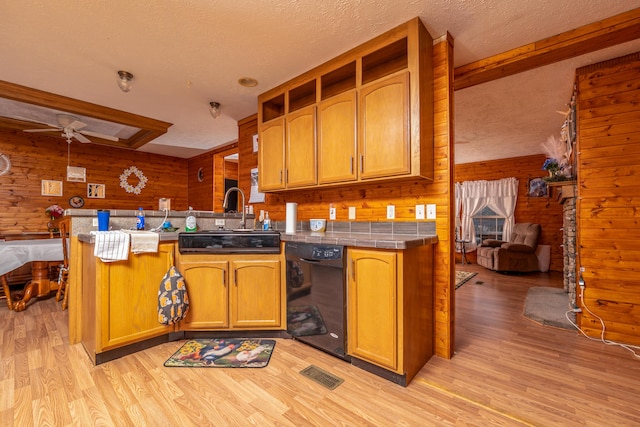 kitchen featuring a sink, washer / clothes dryer, black appliances, and light wood-style flooring