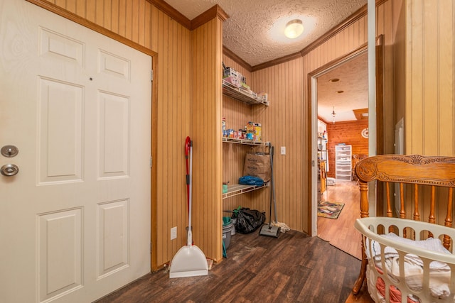 bedroom with ceiling fan, a textured ceiling, wood finished floors, and wood walls