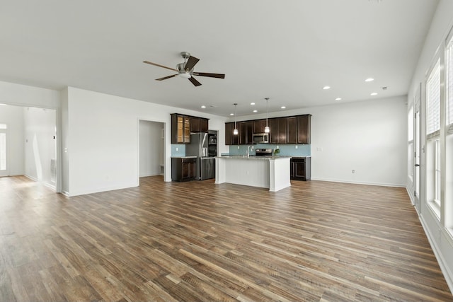 unfurnished living room featuring recessed lighting, baseboards, wood finished floors, and ceiling fan