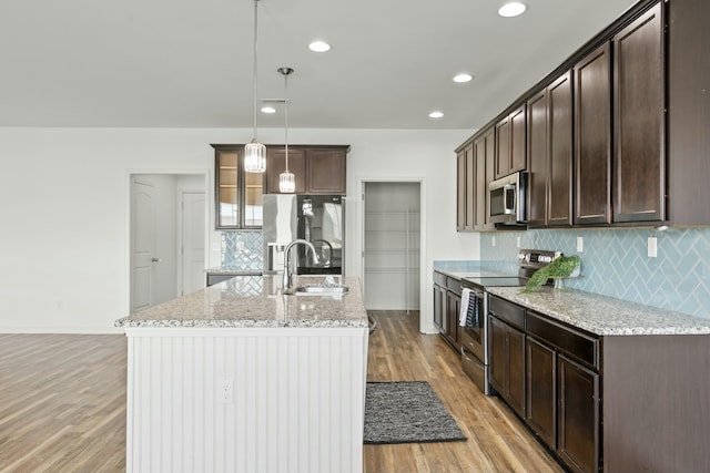 kitchen featuring dark brown cabinetry, appliances with stainless steel finishes, light wood-type flooring, and a sink