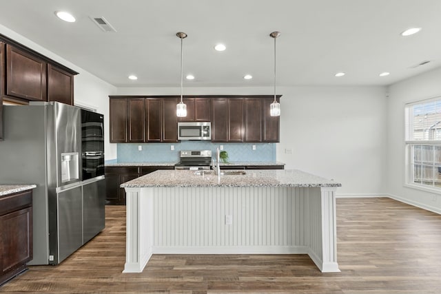 kitchen featuring dark brown cabinetry, wood finished floors, and stainless steel appliances