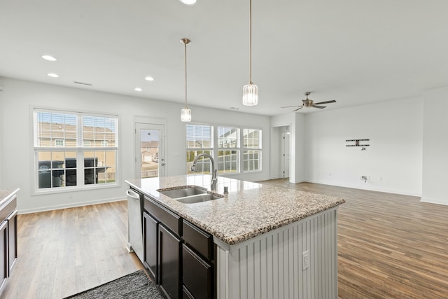 kitchen featuring recessed lighting, light wood-style flooring, stainless steel dishwasher, and a sink