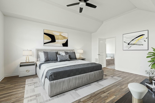 bedroom with connected bathroom, baseboards, wood finished floors, and vaulted ceiling