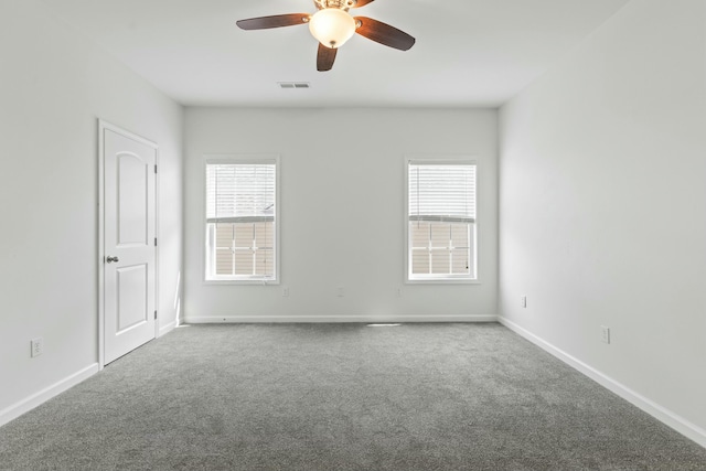 unfurnished room featuring carpet flooring, baseboards, visible vents, and a wealth of natural light