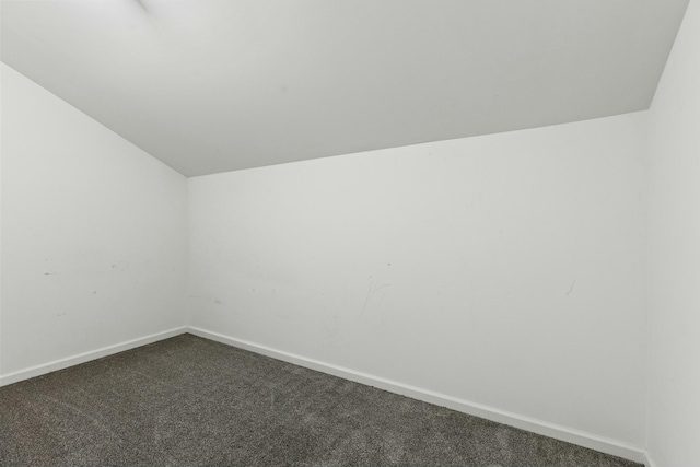 bonus room featuring vaulted ceiling, baseboards, and dark colored carpet