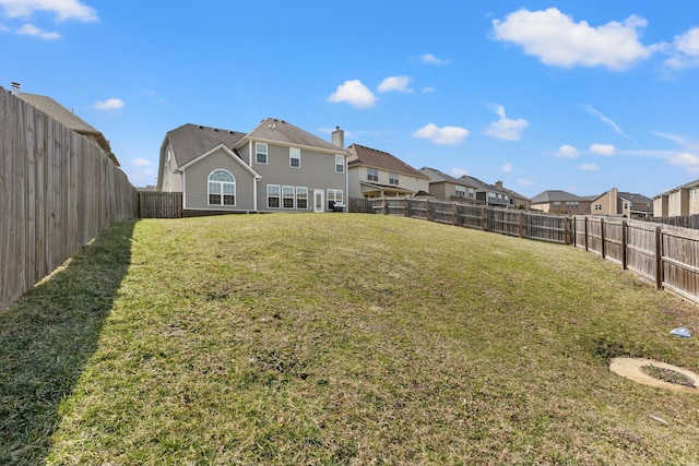 view of yard featuring a fenced backyard and a residential view