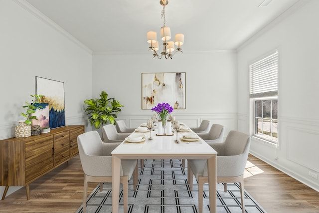 dining room with a chandelier, wood finished floors, and ornamental molding