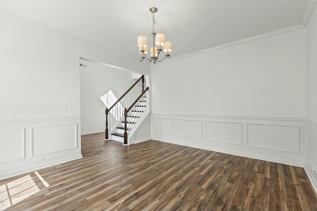 interior space with stairs, dark wood-type flooring, crown molding, a decorative wall, and a chandelier