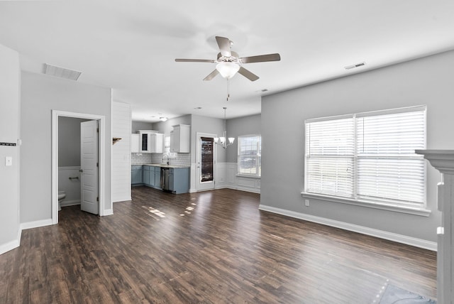 unfurnished living room featuring dark wood finished floors, visible vents, and ceiling fan with notable chandelier