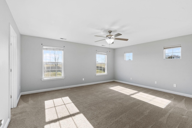 empty room with visible vents, a ceiling fan, baseboards, and carpet floors