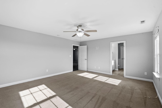 unfurnished bedroom featuring baseboards, visible vents, carpet floors, ceiling fan, and connected bathroom