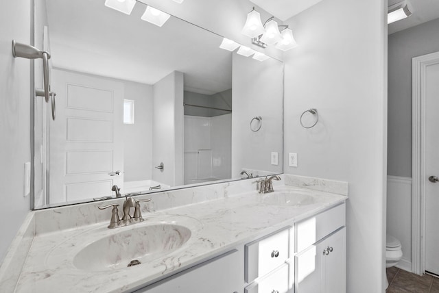 full bath featuring double vanity, tile patterned flooring, toilet, and a sink