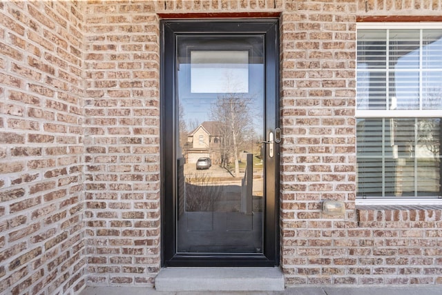 doorway to property with brick siding