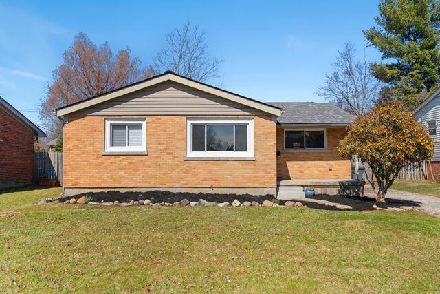 exterior space with a front yard, fence, and brick siding