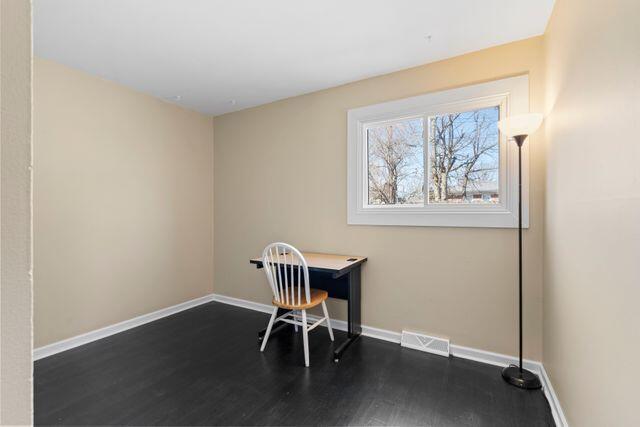 office area featuring dark wood-type flooring, baseboards, and visible vents