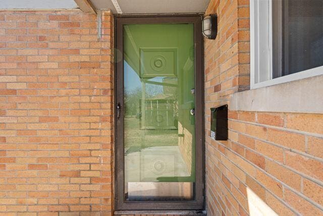 property entrance featuring brick siding