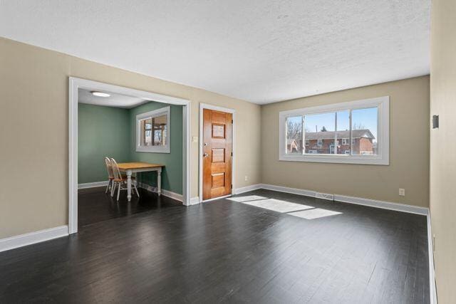 unfurnished room featuring wood finished floors, baseboards, and a textured ceiling