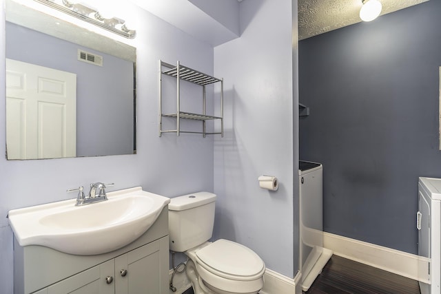 bathroom featuring vanity, baseboards, visible vents, a textured ceiling, and toilet