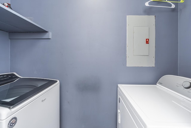 washroom featuring electric panel, laundry area, and washing machine and dryer