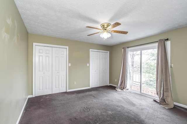 unfurnished bedroom featuring access to exterior, two closets, ceiling fan, carpet, and baseboards