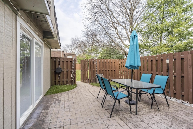 view of patio / terrace with a gate, outdoor dining area, and fence