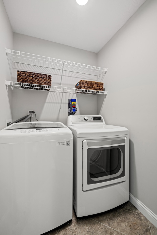 laundry room featuring laundry area, baseboards, and washing machine and clothes dryer