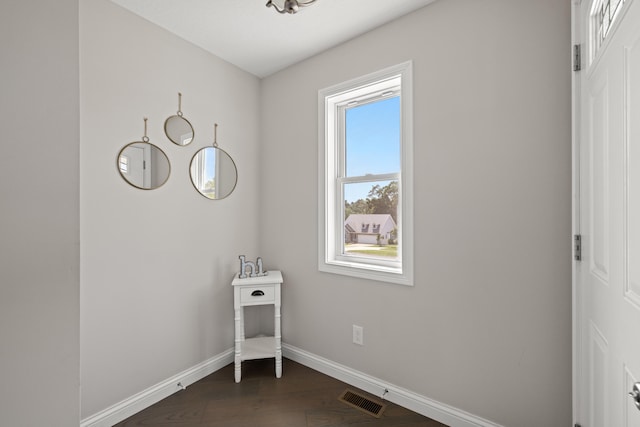 interior space with dark wood-style floors, visible vents, and baseboards