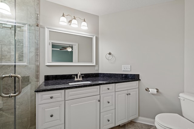 full bathroom featuring a stall shower, toilet, vanity, and baseboards