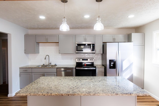 kitchen with gray cabinetry, stainless steel appliances, dark wood-type flooring, and a sink