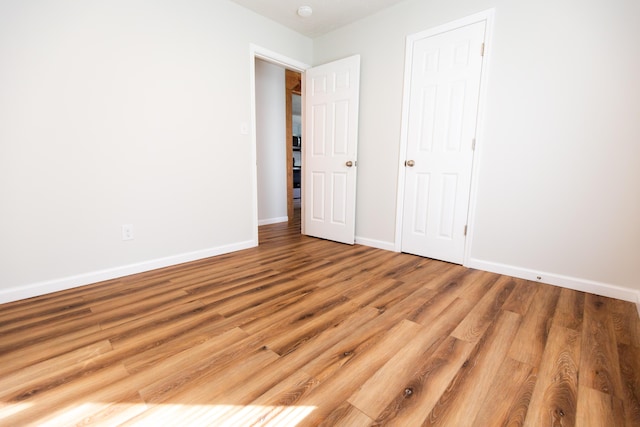 unfurnished bedroom featuring wood finished floors and baseboards