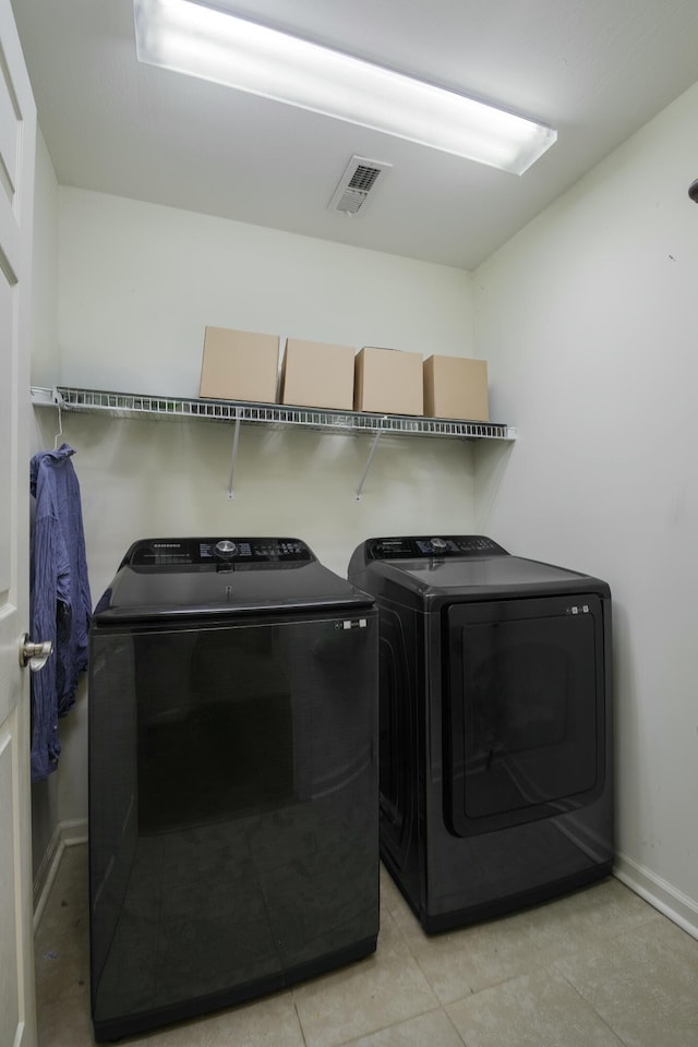 washroom featuring laundry area, baseboards, visible vents, and washer and clothes dryer