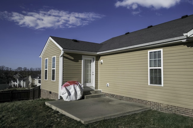 rear view of house featuring a shingled roof, fence, a patio area, entry steps, and crawl space