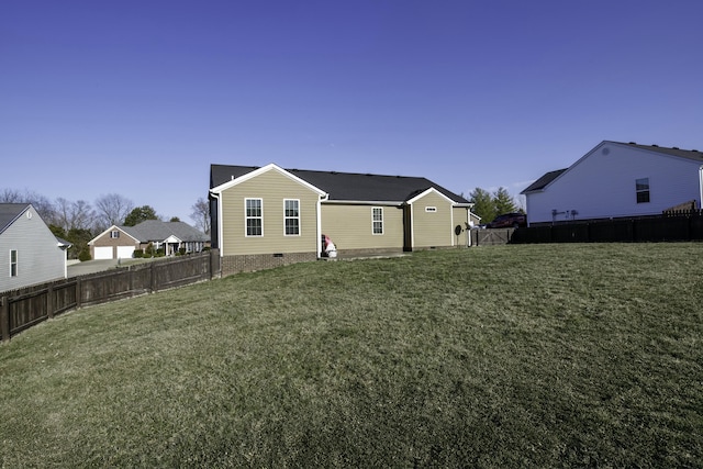 rear view of house featuring crawl space, a lawn, and a fenced backyard