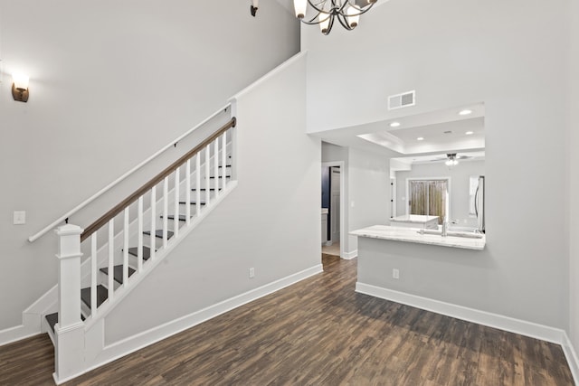 stairway featuring visible vents, baseboards, and wood finished floors