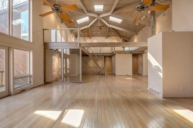 unfurnished living room featuring a ceiling fan, wood-type flooring, and high vaulted ceiling