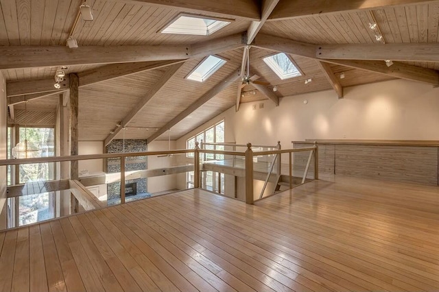 additional living space featuring wood-type flooring, wood ceiling, and vaulted ceiling with skylight