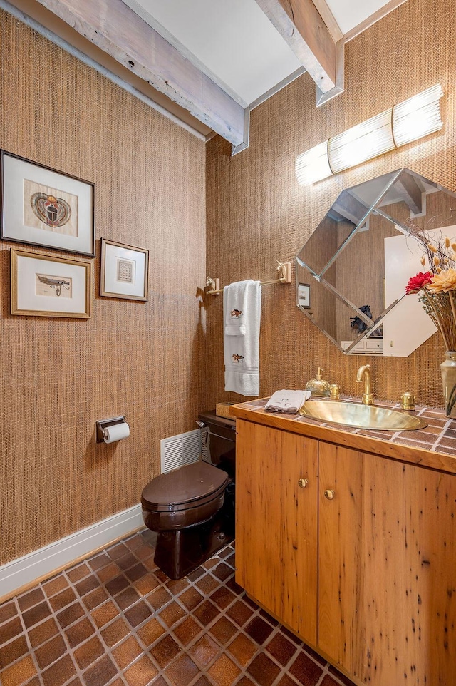 bathroom featuring beamed ceiling, visible vents, toilet, baseboards, and vanity