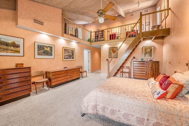 bedroom featuring visible vents, beam ceiling, carpet flooring, wooden ceiling, and a high ceiling