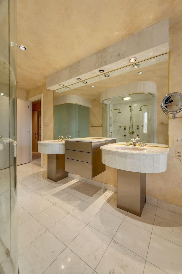 bathroom with a sink, an enclosed shower, and tile patterned flooring