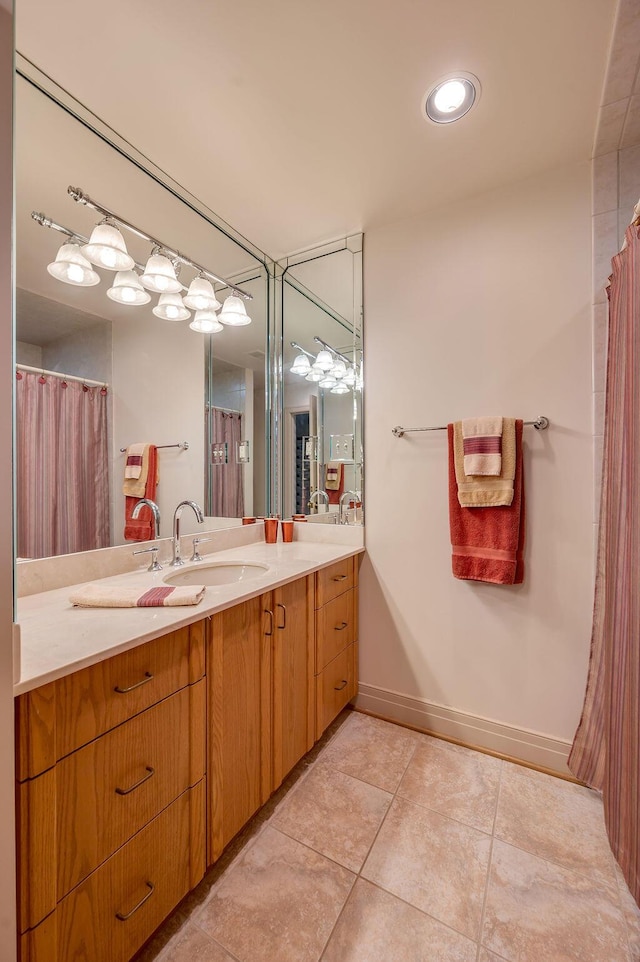 bathroom with tile patterned floors, vanity, and baseboards