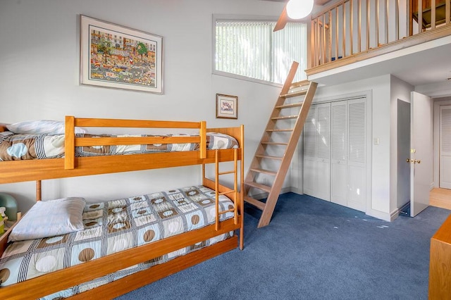 carpeted bedroom featuring a closet, baseboards, and a high ceiling