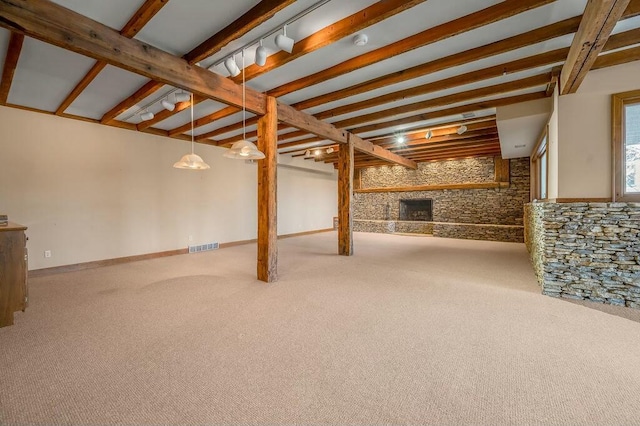 below grade area with a fireplace, rail lighting, carpet, and baseboards