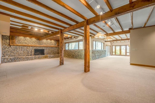 basement featuring a stone fireplace and carpet floors