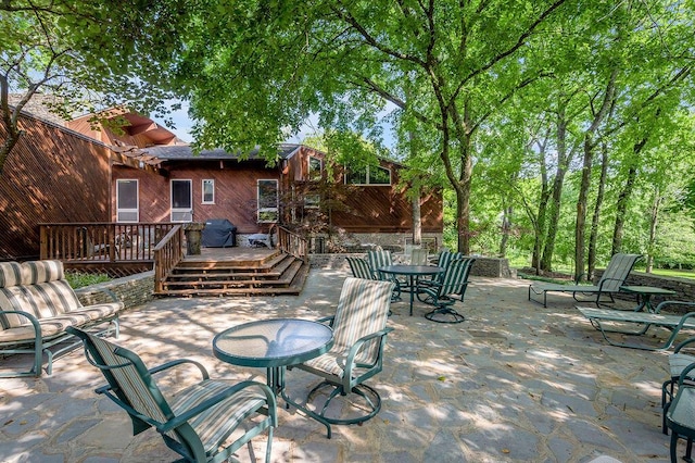 view of patio featuring outdoor dining area and a wooden deck