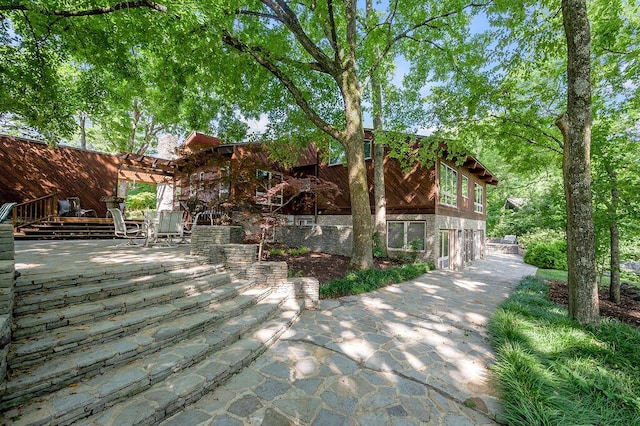 exterior space featuring stone siding and a patio area