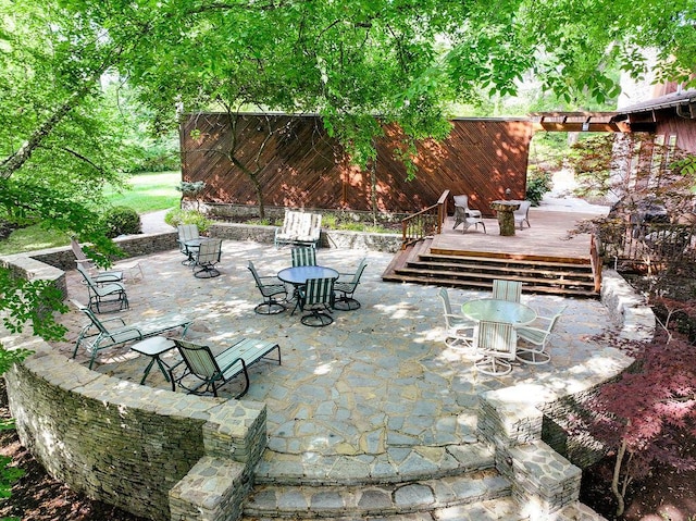 view of patio with outdoor dining space and a wooden deck